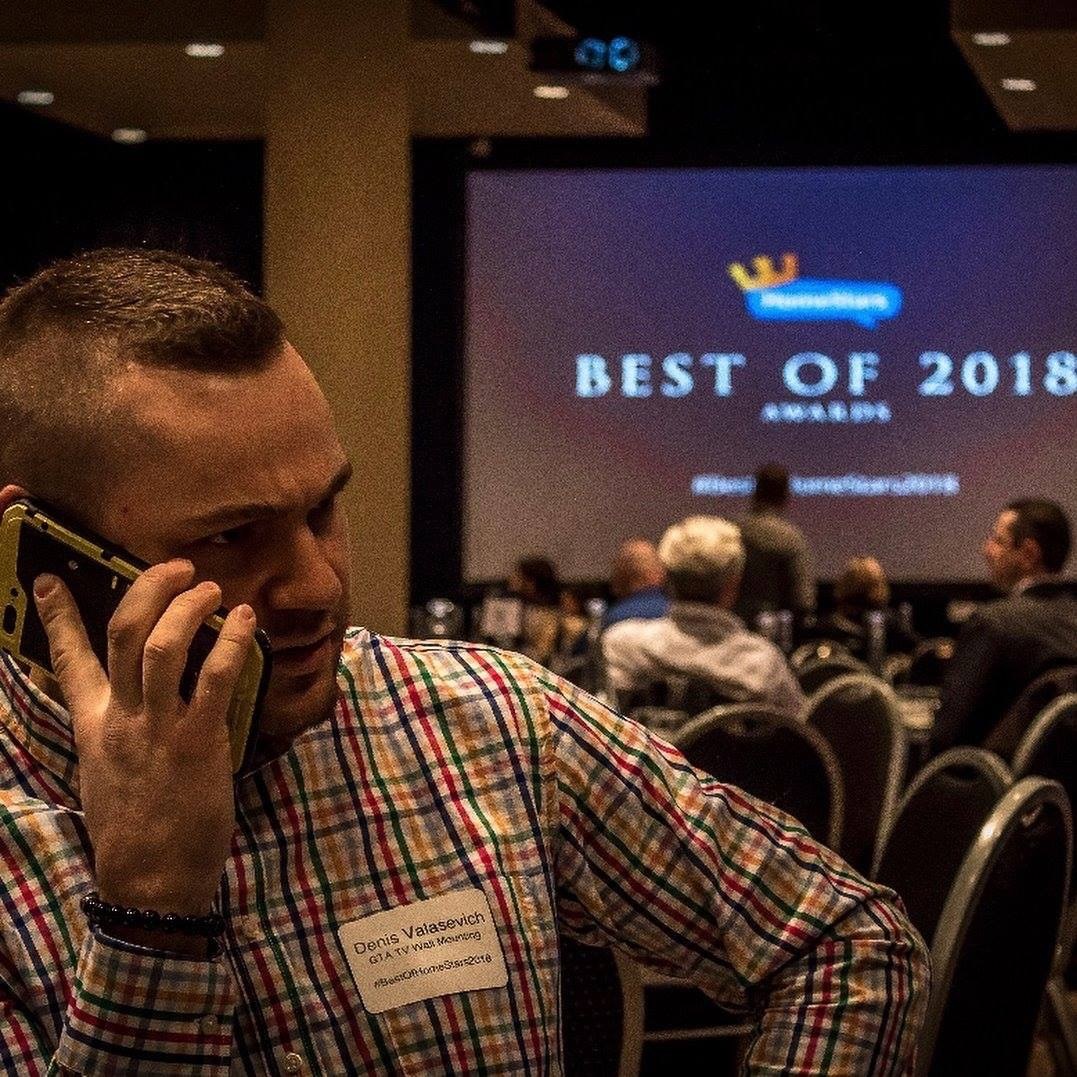 Denis Valasevich taking a call at the HomeStars Best of 2018 Awards, wearing a name badge reading Denis Valasevich, GTA TV Wall Mounting