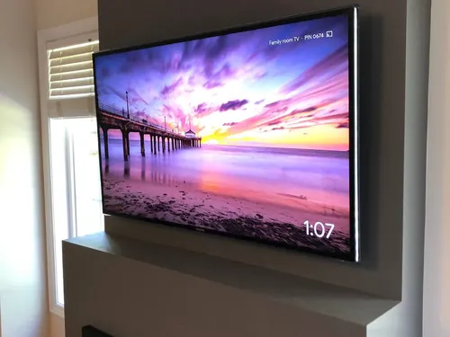 TV mounted on a projecting family room wall, angled toward the seating