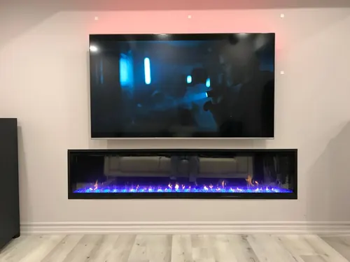 Large TV mounted above a long recessed linear electric fireplace, with cove lighting behind the screen