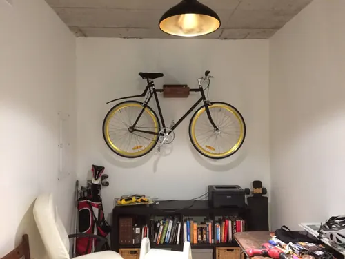 Bicycle hung on a wall mount in a basement storage room