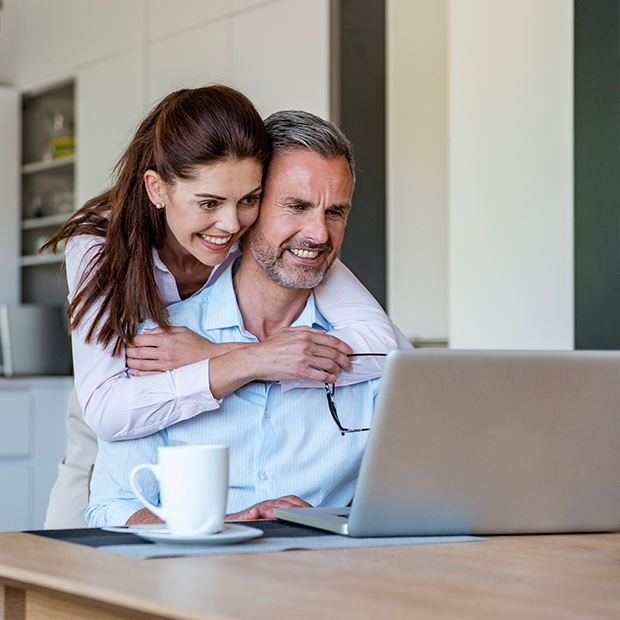 Happy Couple At Table At Home Sharing A Laptop 2022 03 08 01 04 27 A3k2pyd